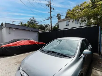 a silver car parked next to a fence with a cover at Cozy Studio, Studio City Unit 3 in Los Angeles