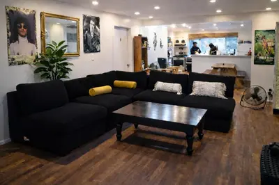 a living room with a black couch and a coffee table at Robertson Homes of Love in Los Angeles