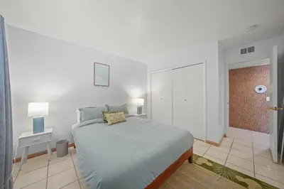 a white bedroom with a bed and a brick wall at Spacious 5 Bedroom Home Near Disneyland & Knotts with Jacuzzi Spa in Norwalk