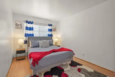 a bedroom with a bed with a red blanket on it at Spacious 5 Bedroom Home Near Disneyland & Knotts with Jacuzzi Spa in Norwalk