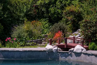 a bench in a garden next to a pond at Newly remodeled home w pool & private back yard in Thousand Oaks