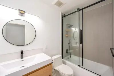 a bathroom with a toilet and a sink and a mirror at Newly remodeled home w pool & private back yard in Thousand Oaks