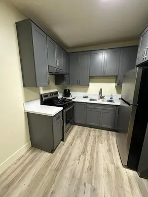 a kitchen with gray cabinets and a sink and a refrigerator at Shared room, Prime Location LA in Los Angeles