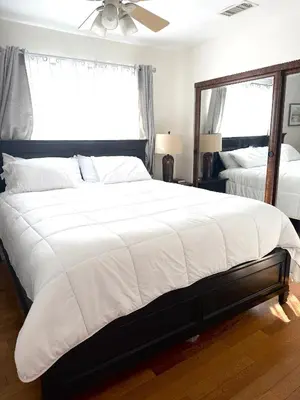 a bedroom with a large white bed and a mirror at Dream House Retreat LLC in Los Angeles