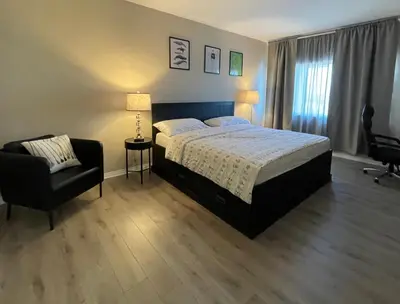 a bedroom with a bed and a chair at Spacious 2 Bed, 2-Bath Apartment in Monterey Park in Monterey Park