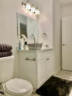 a bathroom with a sink and a toilet and a mirror at Proper Stays at Melrose - West Hollywood Premium R suite in Los Angeles