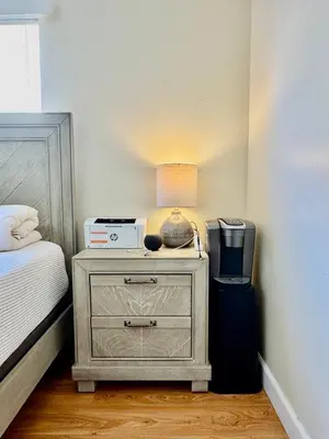 a bedroom with a bed and a night stand with a lamp at Proper Stays at Melrose - West Hollywood Premium R suite in Los Angeles