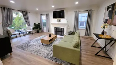 a living room with a green couch and a fireplace at Renovated Three Bedroom Near Cedars Sinai and Beverly Hills With Parking in Los Angeles