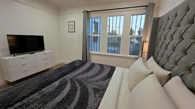 a bedroom with a large bed and a television at Renovated Three Bedroom Near Cedars Sinai and Beverly Hills With Parking in Los Angeles