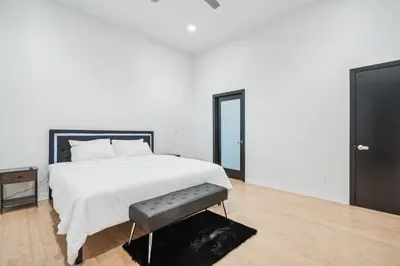a bedroom with a white bed and a black door at Hollywood Hills Luxury Nest Views Pool Spa in Los Angeles