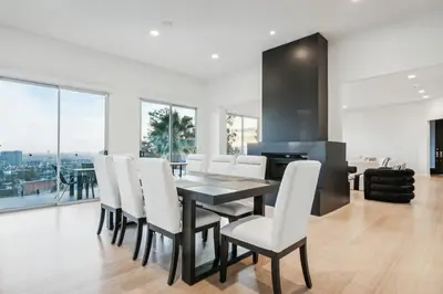 a dining room with a table and white chairs at Hollywood Hills Luxury Nest Views Pool Spa in Los Angeles