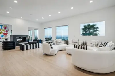 a white living room with white couches and a fireplace at Hollywood Hills Luxury Nest Views Pool Spa in Los Angeles