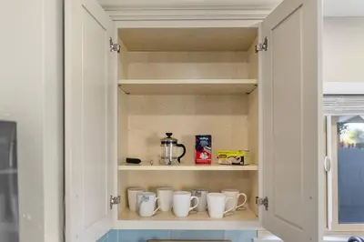 a cupboard with a bunch of cups in it at Near LLU Hospital Calm 3BR Workspace in Loma Linda