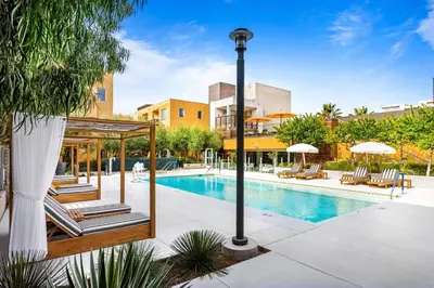 a swimming pool with lounge chairs next to a building at Runway Playa Vista in Los Angeles