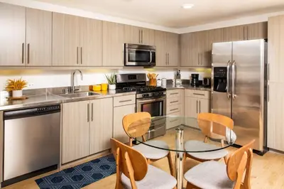 a kitchen with a glass table and stainless steel appliances at Runway Playa Vista in Los Angeles