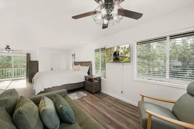 a living room with a bed and a couch at Mockingbird Retreat - Walk to the Lake, hot tub, EV charger, Fenced yard. in Big Bear Lake