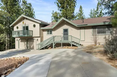 a house with a driveway in front of it at Mockingbird Retreat - Walk to the Lake, hot tub, EV charger, Fenced yard. in Big Bear Lake
