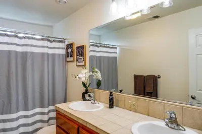 a bathroom with two sinks and a large mirror at BBQ Ready Home 7 Mi to The Park at River Walk in Bakersfield