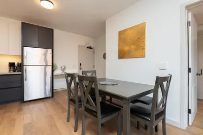 a kitchen with a table and chairs and a refrigerator at Modern Hollywood Apt with Pool Spa & Great Views in Los Angeles