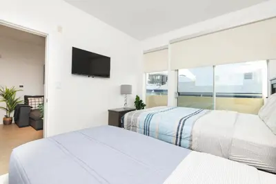a bedroom with two beds and a large window at Walk to Santa Monica Beach & Pier Boardwalk in Los Angeles