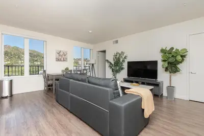 a living room with a couch and a flat screen tv at Snazzy 3BR Apt Hollywood with Pool & Spa in Los Angeles