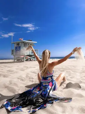 a woman in a dress sitting on the beach at Promenade Studio With Free Parking in Los Angeles