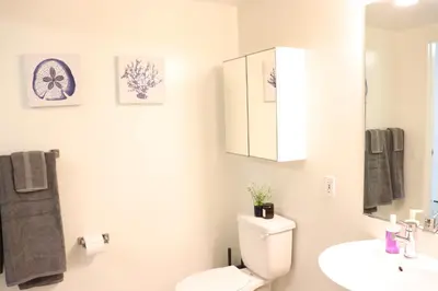 a white bathroom with a toilet and a sink at Promenade Studio With Free Parking in Los Angeles