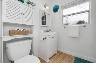 a white bathroom with a toilet and a window at Mar Vista 2BR Retreat Office Huge Backyard in Los Angeles