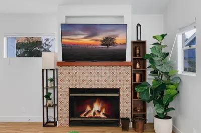 a living room with a fireplace with a television above it at Mar Vista 2BR Retreat Office Huge Backyard in Los Angeles
