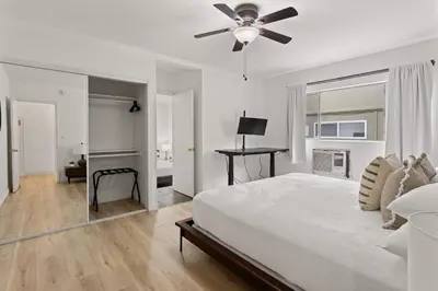 a white bedroom with a bed and a ceiling fan at Relax in Stylish 3BR with Fire Pit Gym and Parking in Los Angeles