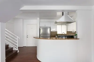 a kitchen with white cabinets and a stainless steel refrigerator at Luxury 4BR Townhouse Sleeps 10 with Parking in McNeil