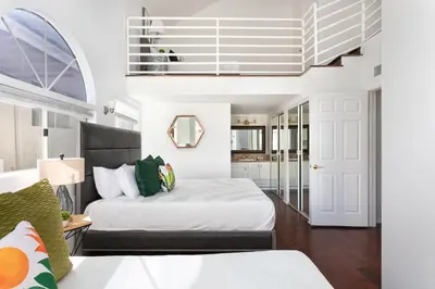 a bedroom with a bed and a staircase at Luxury 4BR Townhouse Sleeps 10 with Parking in McNeil