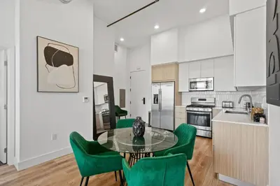 a kitchen with a glass table and green chairs at Luxury Marina Penthouse Private Suite with Pool in Los Angeles