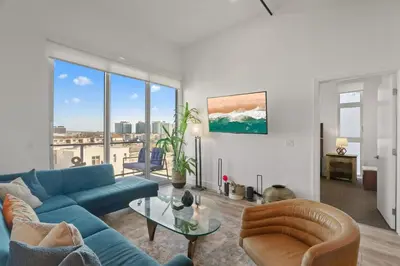 a living room with a blue couch and a glass table at Luxury Marina Penthouse Private Suite with Pool in Los Angeles