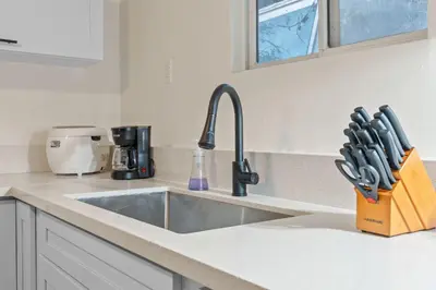 a kitchen counter with a sink and a knife block at Luxe 6BR Retreat with Trampoline Swing and BBQ Grill in Los Angeles