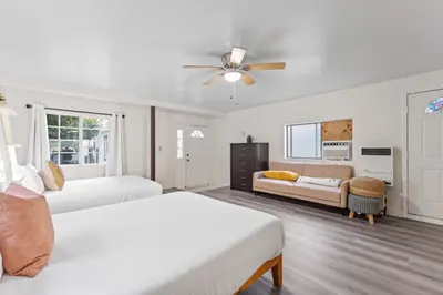 a white bedroom with two beds and a ceiling fan at Luxe 6BR Retreat with Trampoline Swing and BBQ Grill in Los Angeles