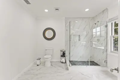 a white bathroom with a shower and a toilet at Luxe 6BR Retreat with Trampoline Swing and BBQ Grill in Los Angeles
