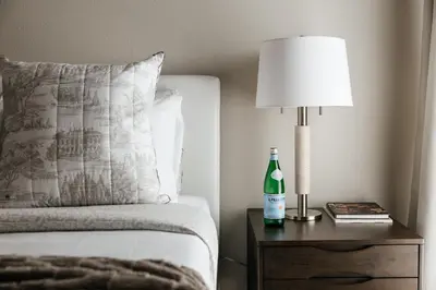 a bed with a bottle of wine on a table with a lamp at Upscale 1BD - Prime West Hollywood Location in Los Angeles