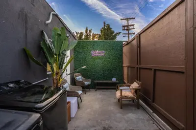 a balcony with chairs and a green wall at Sleek Premium Studio Near The Grove & Fairfax in Los Angeles