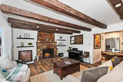 a living room with a fireplace and a piano at Highland Cedar Cabin WHot Tub Close to Village in Big Bear Lake