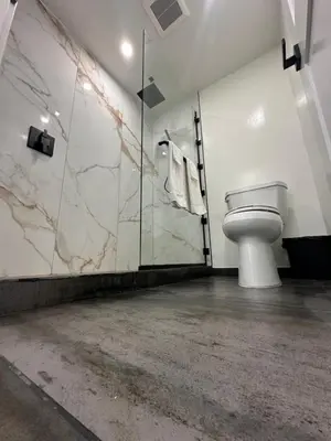 a bathroom with a toilet and a glass shower at Nubell Motel in Bell