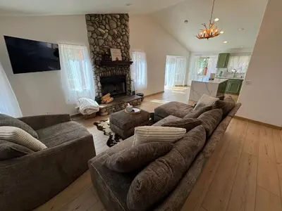 a living room with a large couch and a fireplace at Lakewood Timber Lodge Peaceful Private in Big Bear Lake