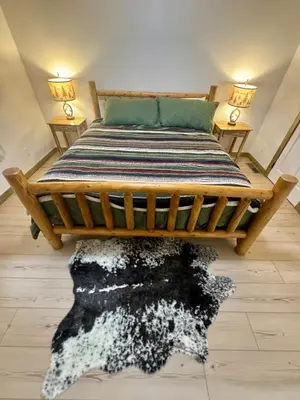 a bedroom with a wooden bed with a black and white rug at Lakewood Timber Lodge Peaceful Private in Big Bear Lake