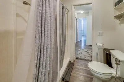 a white bathroom with a toilet and a shower at Extended Stay in the Valley Gated and Convenient! in Tarzana