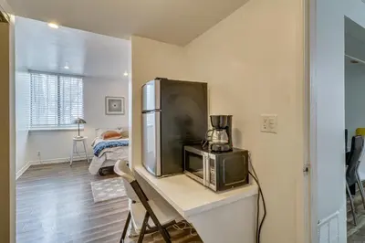 a room with a refrigerator and a table with a tv at Extended Stay in the Valley Gated and Convenient! in Tarzana