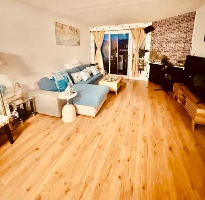 a living room with a couch and a wooden floor at Cozy private room in Santa Monica in Los Angeles