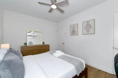 a white bedroom with a bed and a ceiling fan at Mar Vista Beach Escape 2BR with Relaxing Yard in Los Angeles