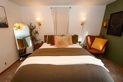 a bedroom with a large bed and a chair at In the Pines Romantic Big Bear Forest Cabin in Fawnskin