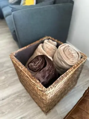 a basket filled with towels on a floor next to a couch at Walkable to SoFi, Intuit Dome, Kia Forum World Cup in Inglewood