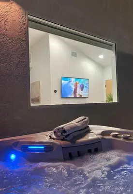 a bathroom with a tub with a tv in a mirror at Castaway Cay near Disney with Hot Tub and Fire Pit in Anaheim